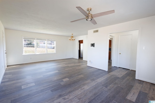 spare room featuring ceiling fan with notable chandelier and dark hardwood / wood-style floors