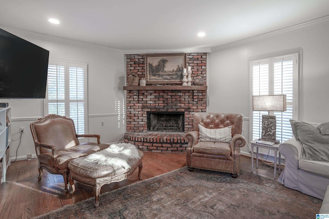 living room with hardwood / wood-style flooring, a fireplace, and crown molding