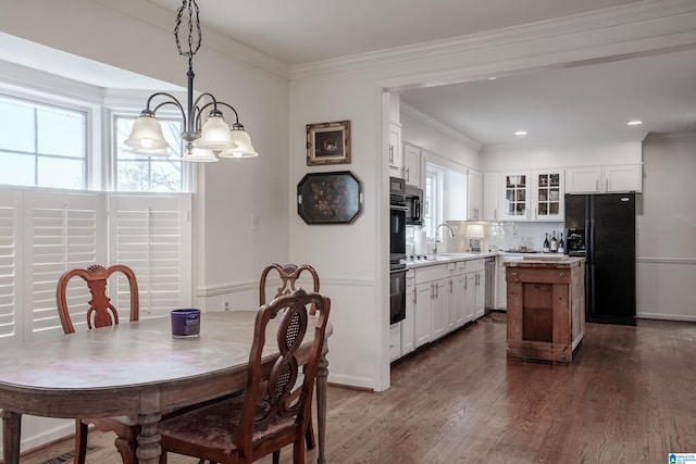 dining space with a notable chandelier, sink, dark wood-type flooring, and a wealth of natural light