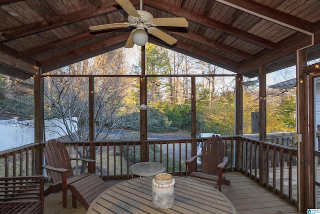 unfurnished sunroom with lofted ceiling with beams, ceiling fan, and wood ceiling