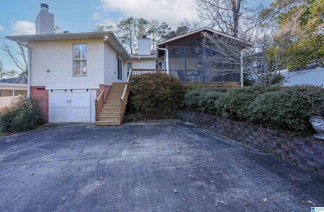 exterior space featuring a garage and a sunroom