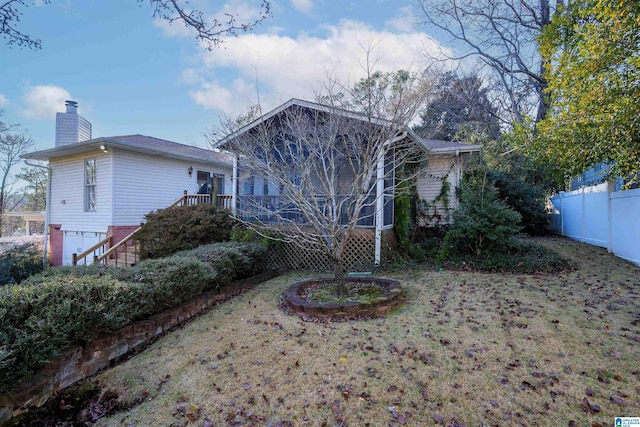 rear view of house with a garage and a lawn