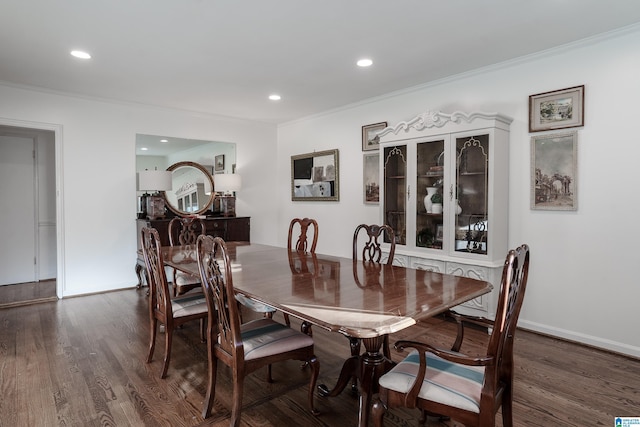 dining area with crown molding and dark wood-type flooring