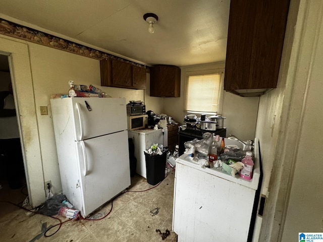 kitchen with dark brown cabinetry and white fridge