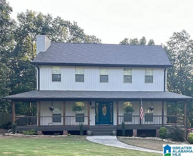 farmhouse featuring covered porch and a front yard