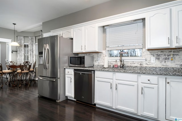 kitchen featuring white cabinetry, sink, decorative light fixtures, and appliances with stainless steel finishes