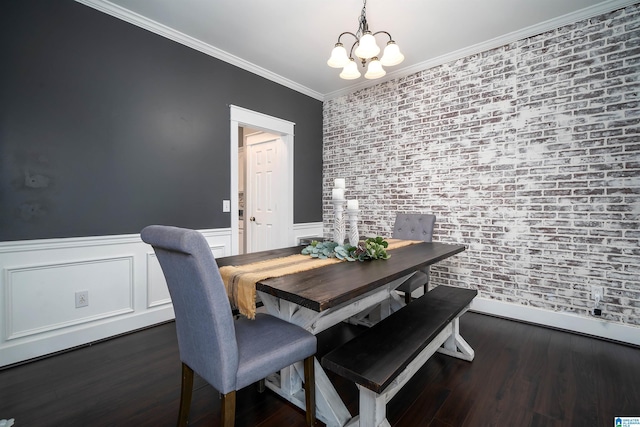 dining room with dark wood-type flooring, a notable chandelier, and ornamental molding