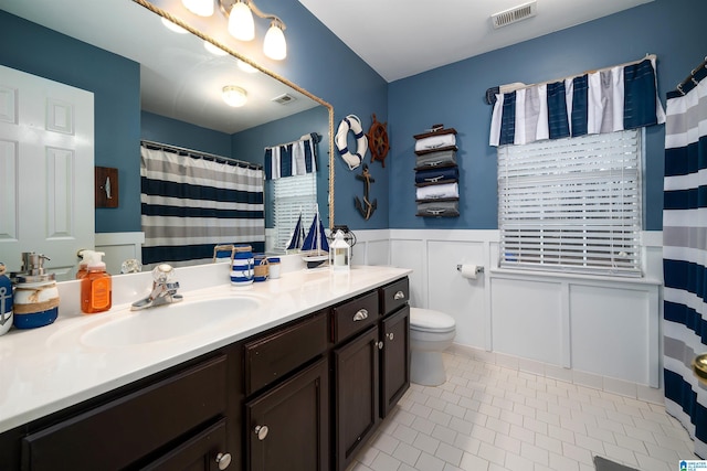 bathroom featuring tile patterned flooring, a shower with curtain, vanity, and toilet