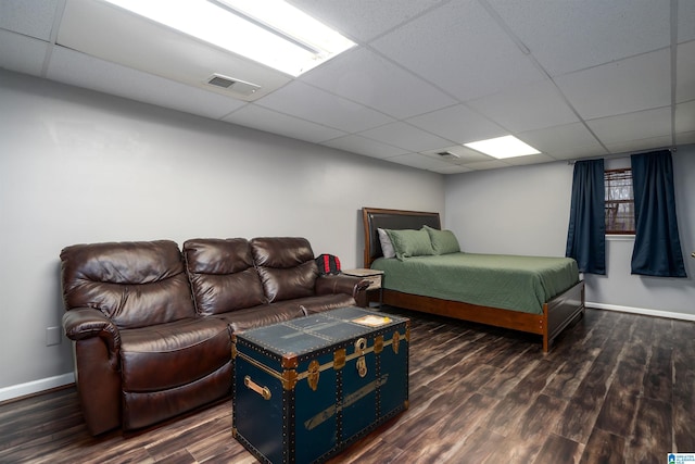 bedroom featuring a paneled ceiling and dark hardwood / wood-style floors