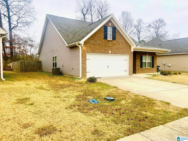 view of front of home with central AC unit, a garage, and a front lawn