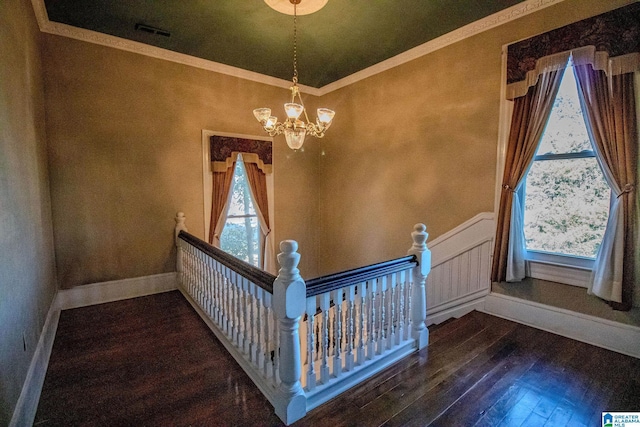 entryway featuring crown molding, dark wood-type flooring, and a notable chandelier