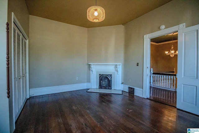 unfurnished living room featuring dark hardwood / wood-style floors and a chandelier