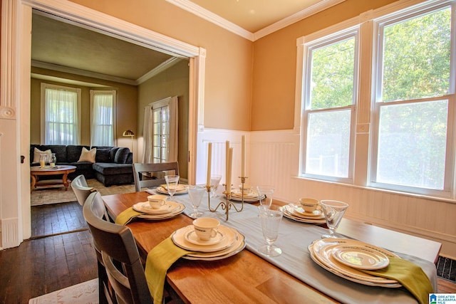 dining area featuring a decorative wall, dark wood-style flooring, a wainscoted wall, and ornamental molding