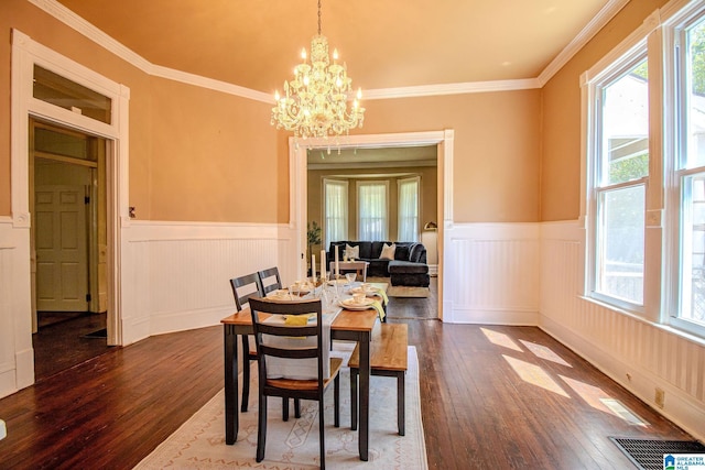 dining area featuring dark wood-type flooring, a chandelier, visible vents, and a wainscoted wall