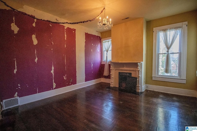 unfurnished living room with wood-type flooring and an inviting chandelier