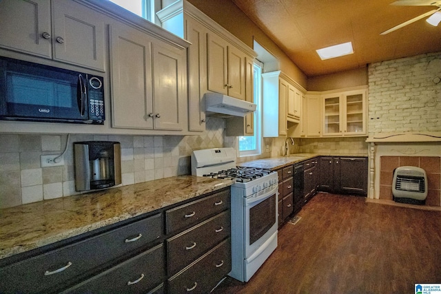 kitchen with dark hardwood / wood-style floors, heating unit, decorative backsplash, white cabinets, and black appliances