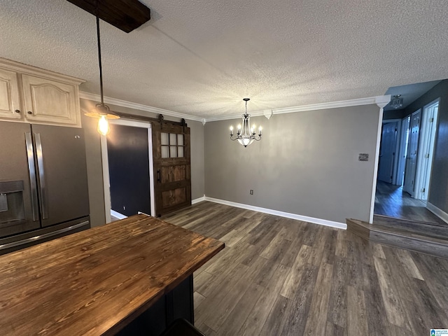 kitchen featuring stainless steel refrigerator with ice dispenser, a barn door, decorative light fixtures, an inviting chandelier, and butcher block counters