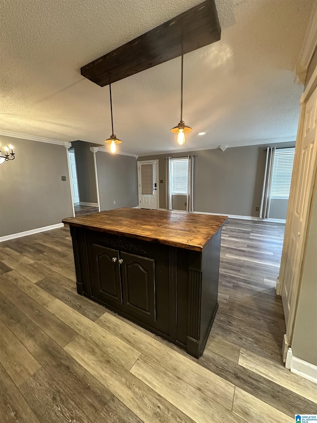 kitchen with hanging light fixtures, light hardwood / wood-style flooring, wooden counters, a textured ceiling, and dark brown cabinets