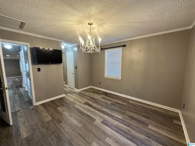 unfurnished dining area featuring dark hardwood / wood-style flooring, a chandelier, a textured ceiling, and ornamental molding