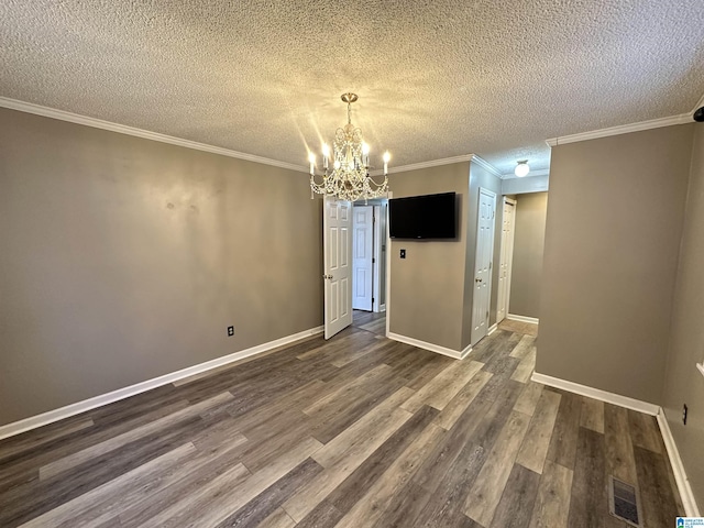 unfurnished dining area with a textured ceiling, dark hardwood / wood-style flooring, an inviting chandelier, and ornamental molding