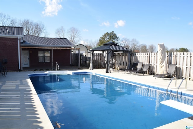 view of pool with a gazebo, a diving board, and a patio area