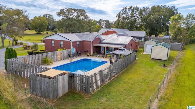 view of swimming pool with a gazebo, a patio area, a storage shed, and a lawn