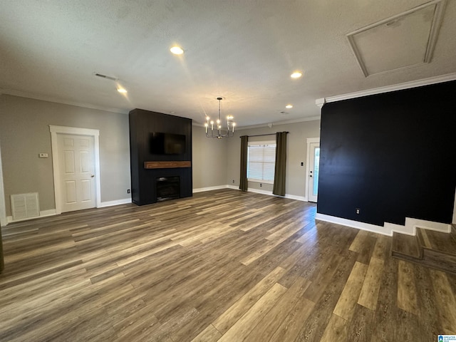 unfurnished living room with a textured ceiling, hardwood / wood-style flooring, and ornamental molding