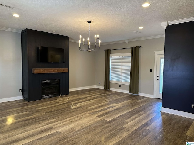 unfurnished living room with a fireplace, dark hardwood / wood-style flooring, a chandelier, and crown molding