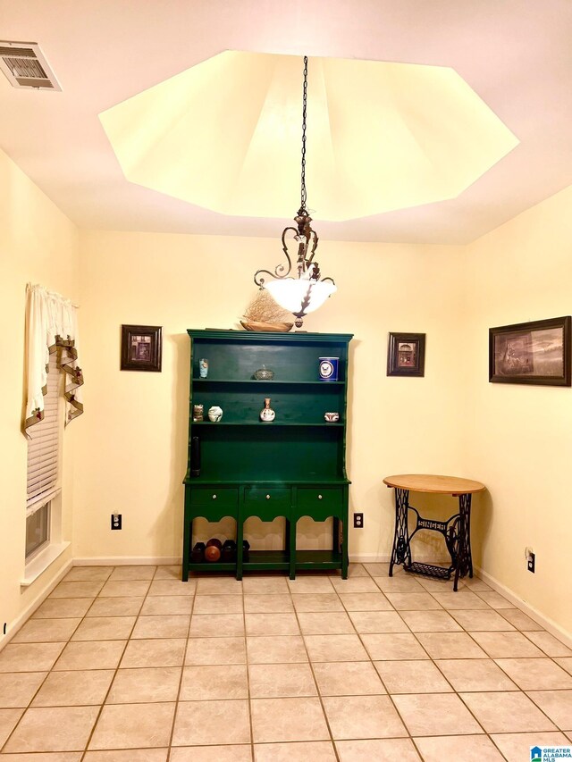 tiled entryway with a notable chandelier