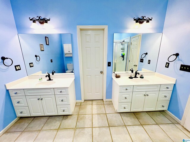 bathroom with tile patterned flooring, vanity, an enclosed shower, and toilet