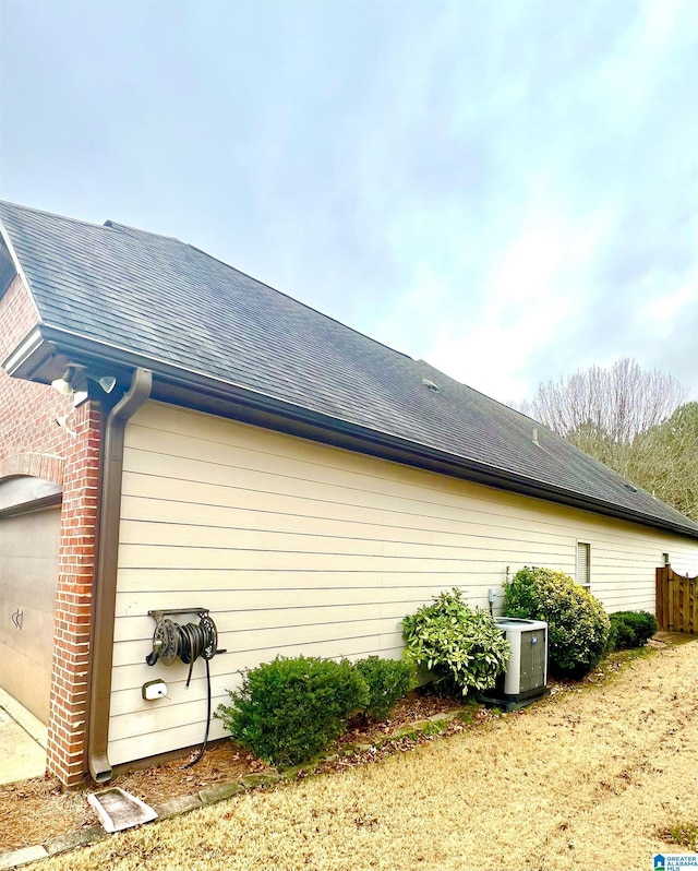 view of side of home featuring a garage and central AC