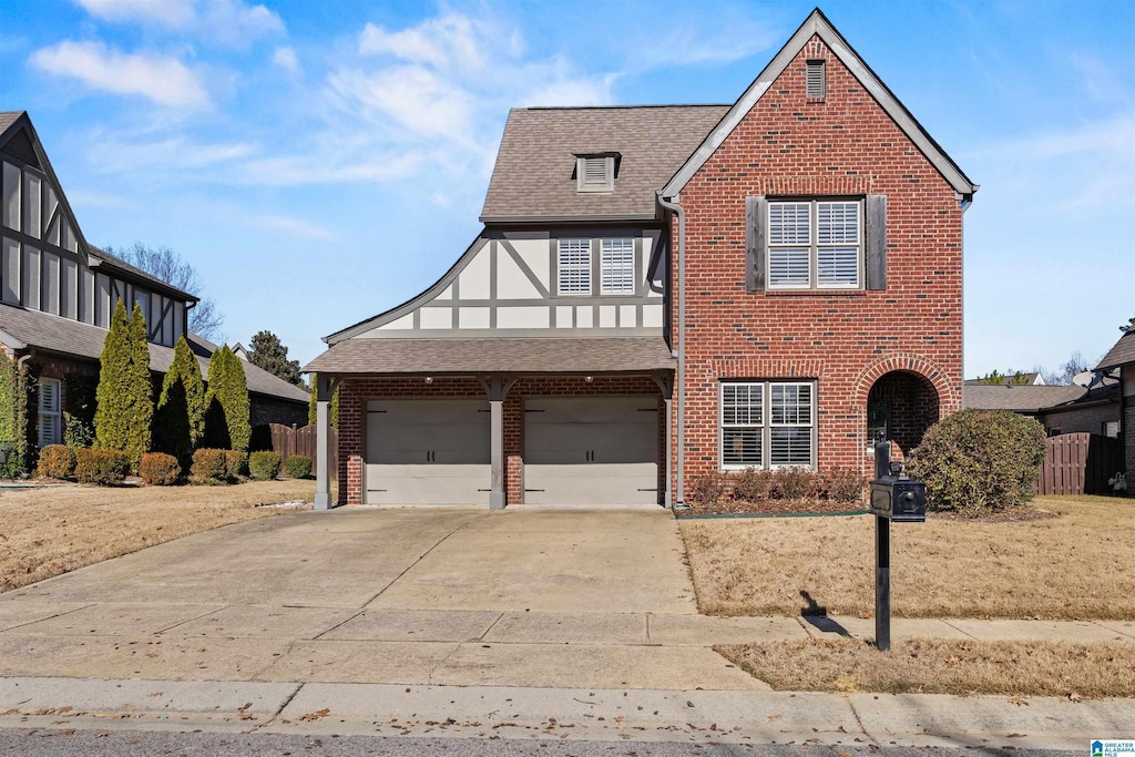 english style home featuring a garage