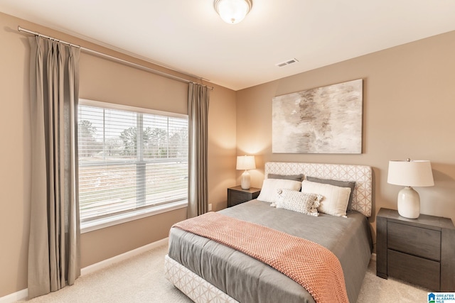 bedroom with light carpet and multiple windows