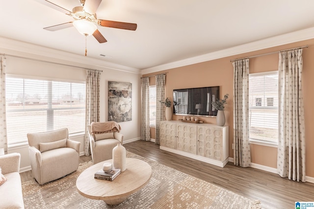 living room featuring hardwood / wood-style floors, a wealth of natural light, ornamental molding, and ceiling fan