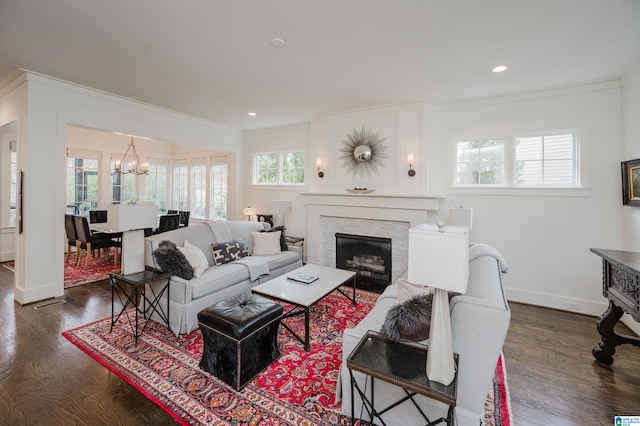 living room with crown molding, dark hardwood / wood-style flooring, and an inviting chandelier