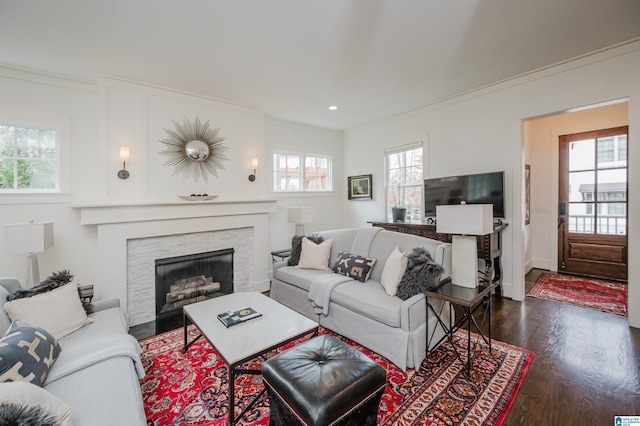 living room with dark hardwood / wood-style floors and crown molding