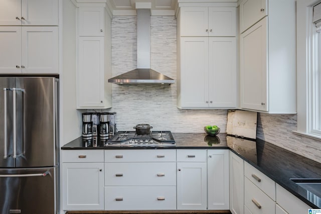 kitchen featuring white cabinets, wall chimney exhaust hood, and appliances with stainless steel finishes