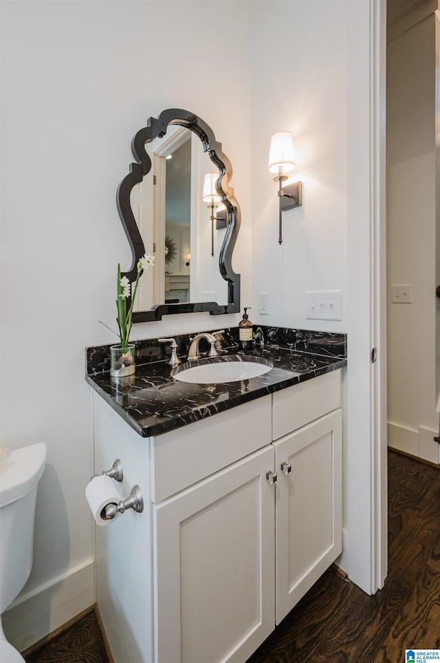 bathroom with hardwood / wood-style flooring, vanity, and toilet