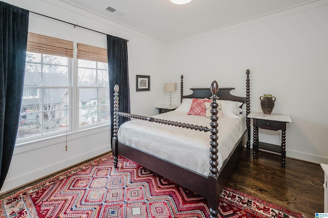 bedroom with dark hardwood / wood-style floors and ornamental molding