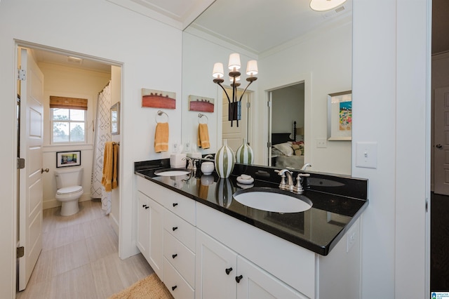 bathroom with toilet, vanity, a shower with shower curtain, and ornamental molding