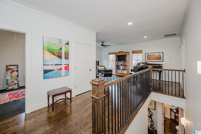 hall with dark wood-type flooring and crown molding