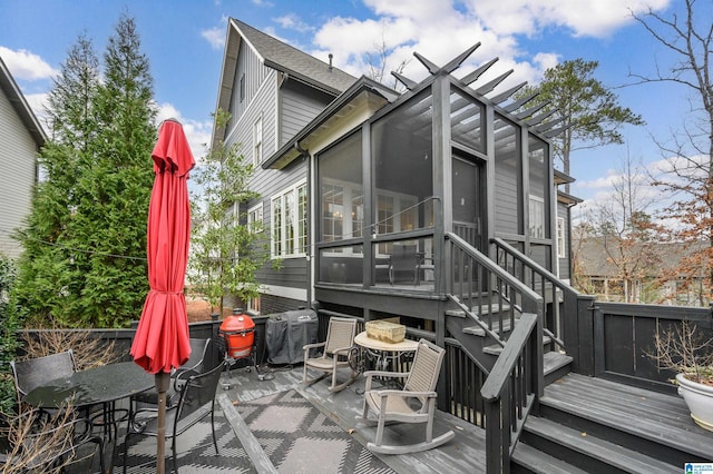 rear view of property with a sunroom and a deck