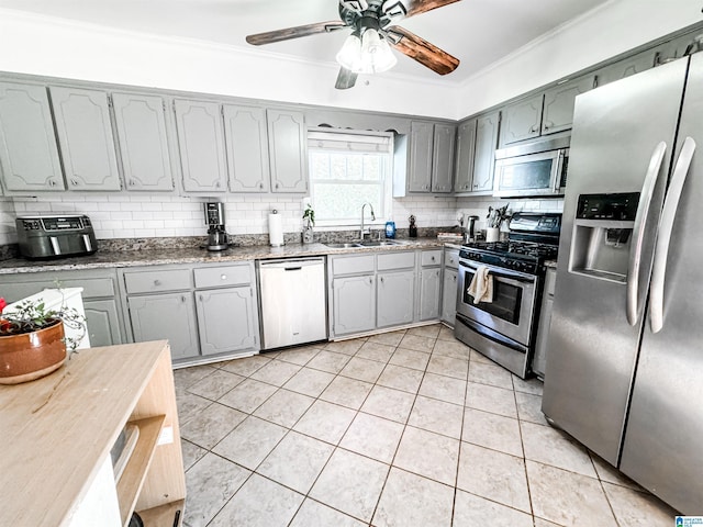 kitchen featuring sink, stainless steel appliances, tasteful backsplash, gray cabinets, and light tile patterned flooring