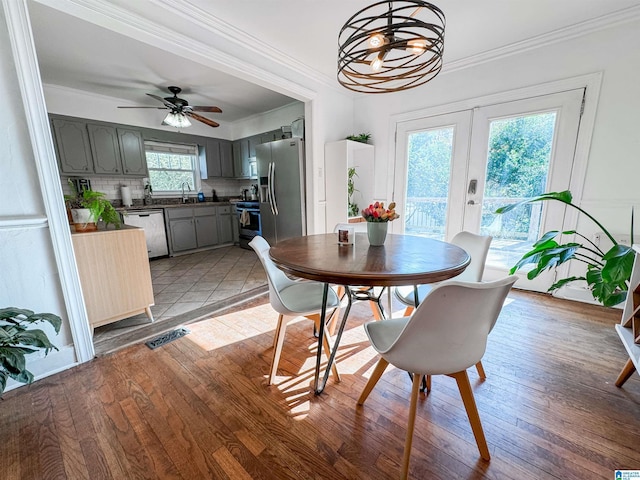 dining room with a wealth of natural light, french doors, and light hardwood / wood-style floors