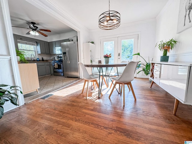 dining area with sink, a healthy amount of sunlight, french doors, and light hardwood / wood-style flooring