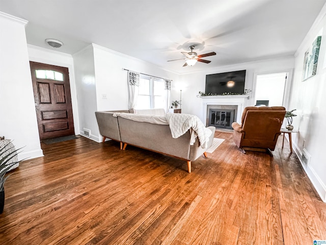 living room featuring wood-type flooring, ceiling fan, and crown molding