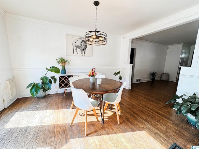 dining room with an inviting chandelier, wood-type flooring, and ornamental molding