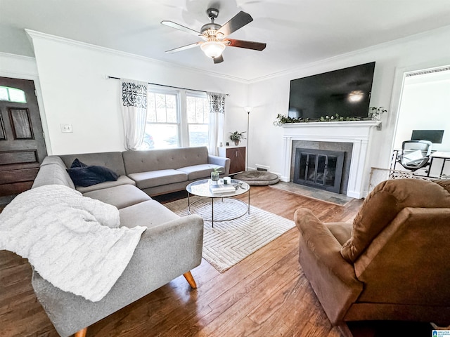 living room featuring ceiling fan, wood-type flooring, and ornamental molding