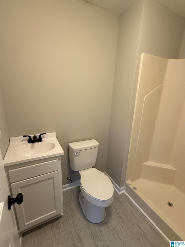 bathroom featuring a shower, vanity, hardwood / wood-style flooring, and toilet