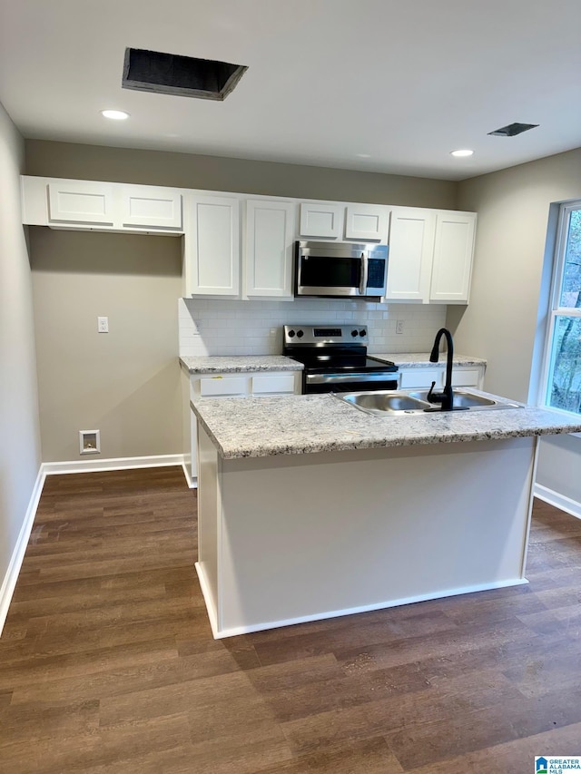 kitchen featuring white cabinetry, sink, stainless steel appliances, dark hardwood / wood-style flooring, and a kitchen island with sink